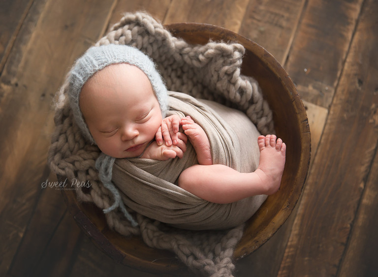 Kingman Arizona Newborn Photographer Baby Jaxon baby boy  wrapped in a bowl blue bonnet wood floor
